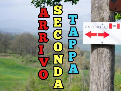 Un cartello su un palo con un cartello su un albero. di Albergo Musolesi a Madonna di Fornelli