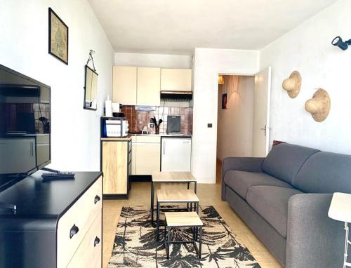 un salon avec un canapé et une cuisine dans l'établissement Arcachon charmant studio sur le port aperçu mer., à Arcachon