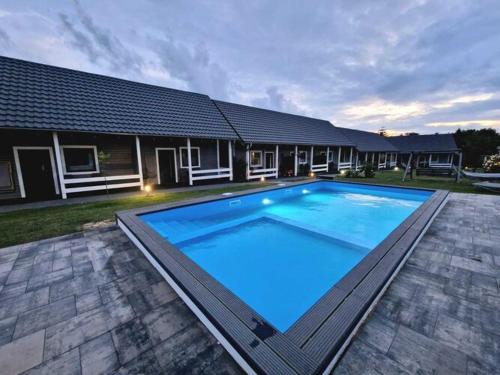 a large swimming pool in front of a house at Terraced Houses, Rewal in Rewal