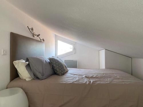 ein Schlafzimmer mit einem Bett mit Kissen darauf in der Unterkunft Charming house close to the Plage des Huttes in Chaucre