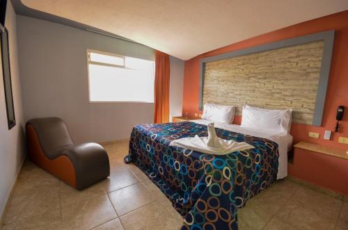a hotel room with a bed and a chair at Motel Venecia in Momoxpan