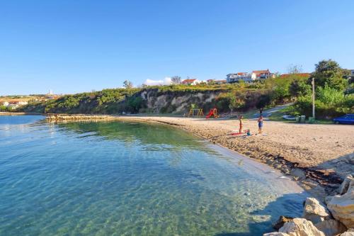two people standing on a beach near the water at Holiday Stone House - Fumarea in Rtina