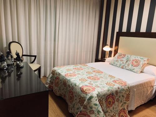 ein Hotelzimmer mit einem Bett und einer Kommode mit einem Bett sidx sidx sidx in der Unterkunft APARTAMENTO MOZART PORTONOVO Centro in Sanxenxo