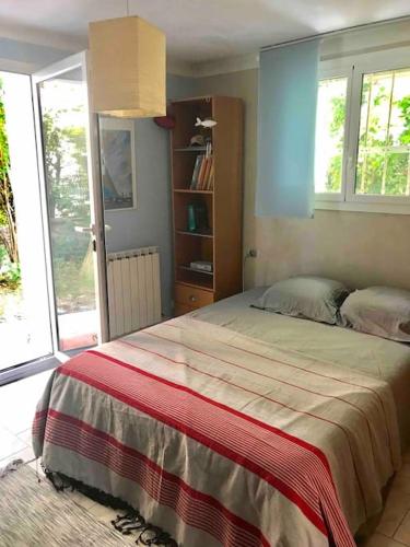 une chambre avec un grand lit et une fenêtre dans l'établissement Villa calme grand jardin bord de mer. Parking, à Marseille