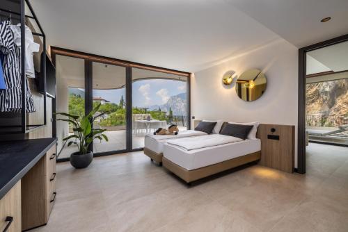 a living room with a white couch and a large window at Gardea SoulFamily Resort in Nago-Torbole