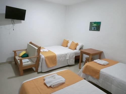 a hotel room with two beds and a tv at Majestic Mical in Yurimaguas