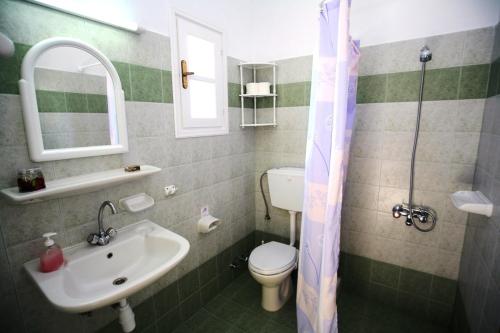 a bathroom with a sink and a toilet and a mirror at Deep Blue Studios in Logaras