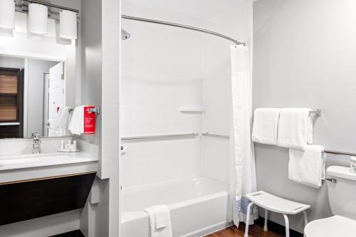 Baño blanco con bañera y lavamanos en TownePlace Suites by Marriott Dallas Plano/Legacy, en Plano