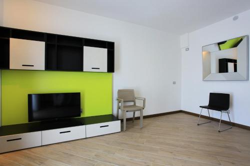 a living room with a flat screen tv and two chairs at Hotel Ponti in Angera