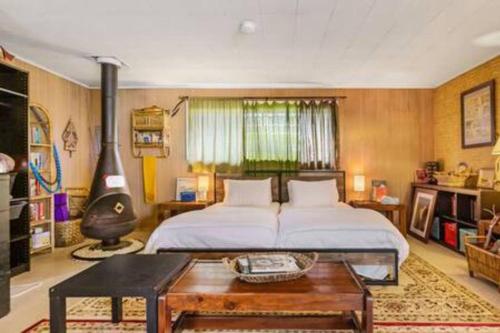 1 dormitorio con 1 cama y 1 mesa en una habitación en Boho Bliss Bungalow, en Shoreline