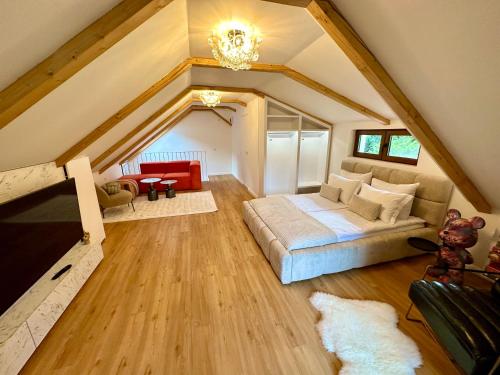 a attic bedroom with a bed and a couch at The Loft in Sovata