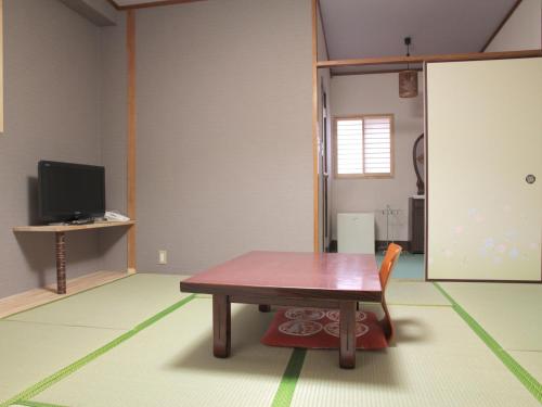 大阪市にあるImazato Ryokan - Vacation STAY 51073vのテーブルとテレビのあるリビングルーム