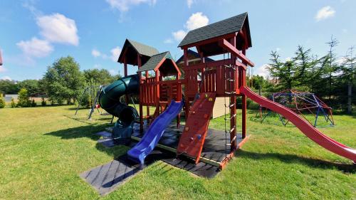 a playground with a slide and a slideintend at Amber Domki Letniskowe in Lubiatowo