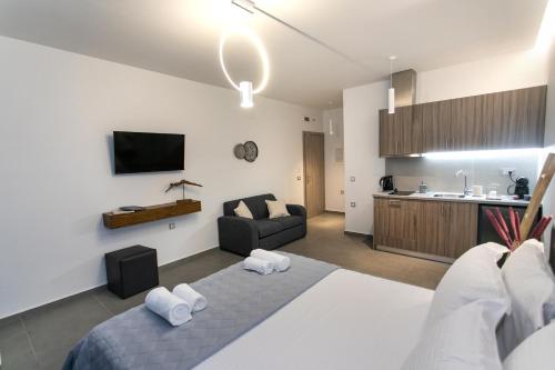 a bedroom with a bed and a couch in a room at Gaia Apartments I in Anthoúsa