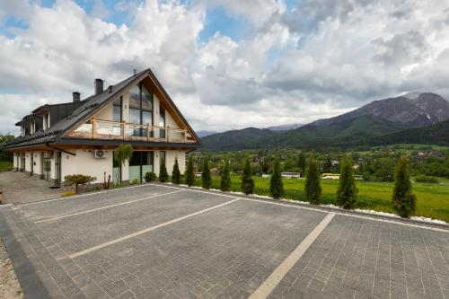 un estacionamiento vacío frente a una casa en IJG Imperial Apartamenty Szymaszkowa, en Zakopane