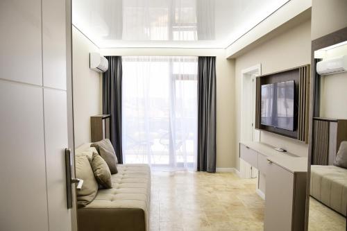 a living room with a couch and a television at AXO Boutique HOTEL by BUILDING STEFAN in Năvodari