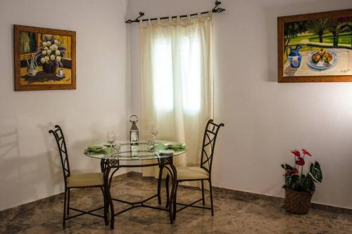 科爾多瓦的住宿－Apartamento Fernando Colón en Casco Histórico，餐桌、两把椅子和窗户