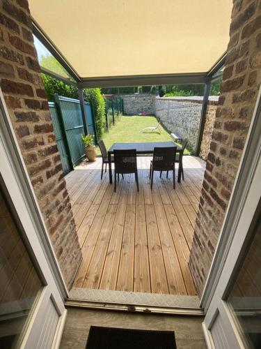 une terrasse en bois avec une table et des chaises. dans l'établissement Neuville secrete, à Dieppe