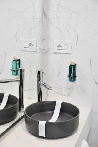 a bathroom with a black sink and two faucets at AXO Boutique HOTEL by BUILDING STEFAN in Mamaia Sat/Năvodari