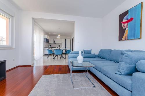 a living room with a blue couch and a table at Apartment Skoko in Slatine