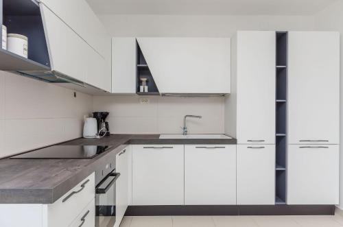 a kitchen with white cabinets and a sink at Apartment Skoko in Slatine