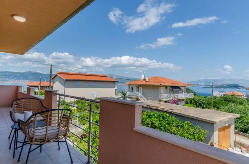 a balcony with chairs and a view of the water at Apartment Skoko in Slatine