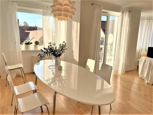 a white dining room with a white table and chairs at Apartamenty Studio W Ustce - 120 m2 - 200 m od plaży Mickiewicza 2, in Ustka