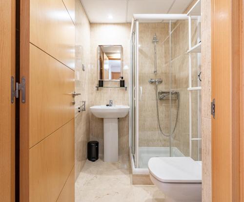 a bathroom with a shower and a toilet and a sink at 11 Modern apt with sea views, two poolareas, close to parks & beaches Manilva in Manilva