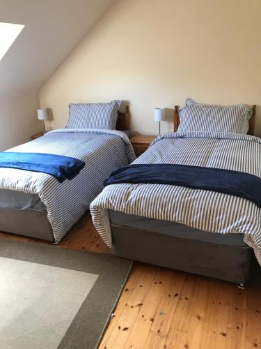 dos camas sentadas una al lado de la otra en un dormitorio en Atlantic View, en Castlegregory