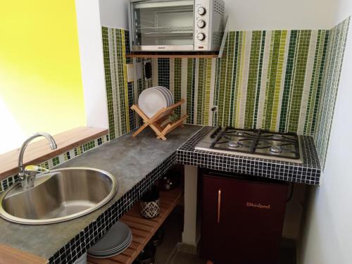 a small kitchen with a sink and a stove at casita moderna frente al bosque in Mar del Plata