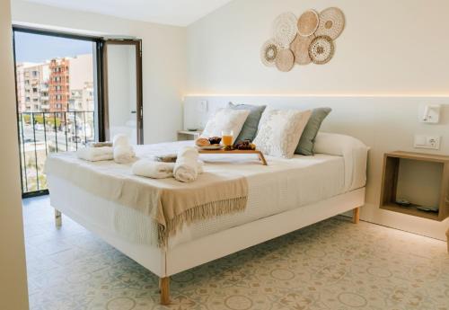 uma cama branca num quarto com lareira em Casa Colgante con vistas panorámicas junto al mar. em Villajoyosa