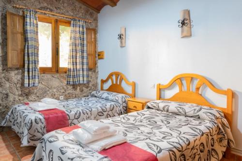 A bed or beds in a room at Casas Rurales Los Enebros Nerpio