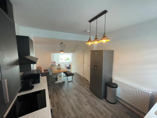 a kitchen with a refrigerator and a table in a room at Leerick Cottage in Conwy
