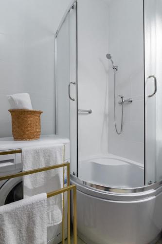 a white bathroom with a shower and a sink at APARTAMENT VINTAGE parter in Płock