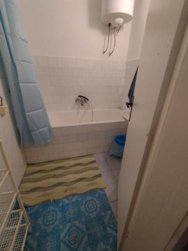 a small bathroom with a tub and a rug at T.I.M. in Bela Crkva