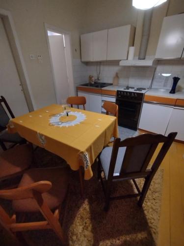 une cuisine avec une table jaune et des chaises dans l'établissement T.I.M., à Bela Crkva