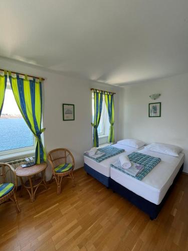 a bedroom with a bed and a table and chairs at Bed&Breakfast Villa Eva in Omišalj