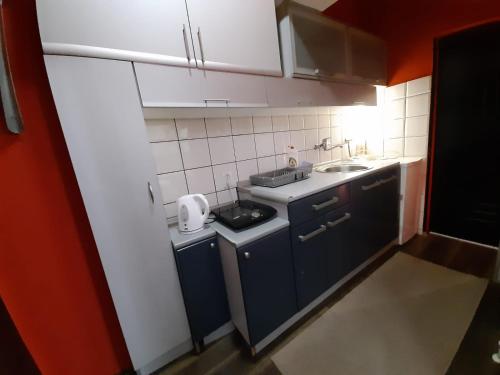 eine kleine Küche mit blauen Schränken und einem Waschbecken in der Unterkunft Apartman Mima in Jagodina