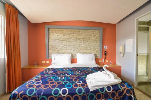 a bedroom with a large bed with an orange wall at Motel Venecia in Momoxpan