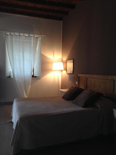 a bedroom with a bed with a lamp and a curtain at Agriturismo Cascina Magana in Burago di Molgora