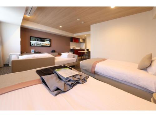 a hotel room with two beds with a robe on the bed at Hotel Torifito Kashiwanoha - Vacation STAY 75951v in Kashiwa