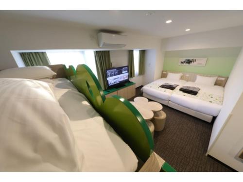 Hotel Torifito Kashiwanoha - Vacation STAY 75950v في كاشيوا: غرفة فندقية بسريرين وتلفزيون بشاشة مسطحة