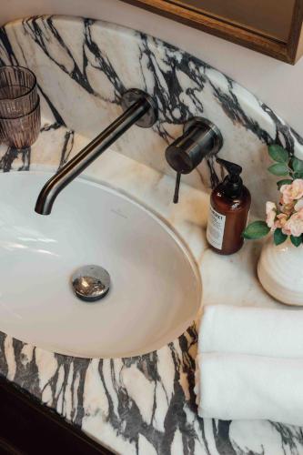 a bathroom sink with a blow dryer on a marble counter at Clemonte Hotel - Your Reception-less Boutique Hideaway in Salzburg