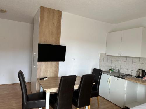 a kitchen with a dining room table with black chairs at Royal Apartments in Neum
