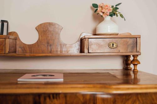 a wooden table with a vase on top of a table at Clemonte Hotel - Your Reception-less Boutique Hideaway in Salzburg