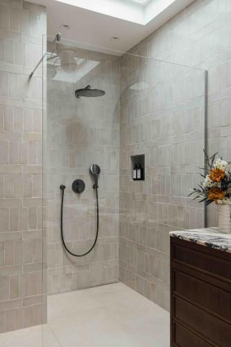 a shower with a shower head in a bathroom at Clemonte Hotel - Your Reception-less Boutique Hideaway in Salzburg