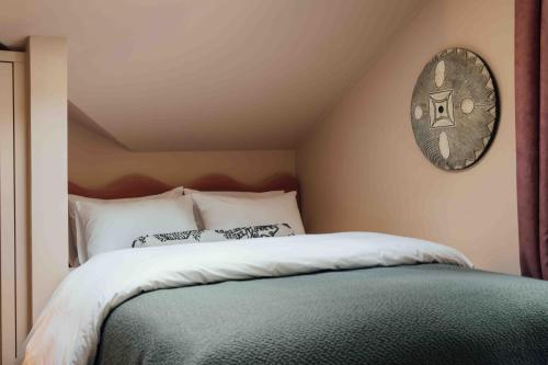 a bedroom with a bed with a clock on the wall at Clemonte Hotel - Your Reception-less Boutique Hideaway in Salzburg
