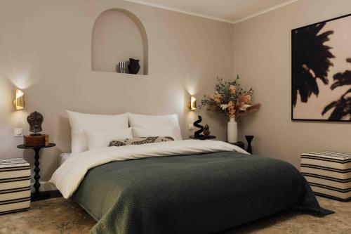 a bedroom with a large bed with a green blanket at Clemonte Hotel - Your Reception-less Boutique Hideaway in Salzburg