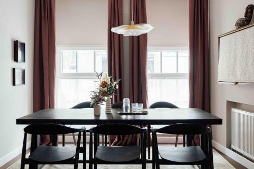 a dining room with a black table and chairs at Clemonte Hotel - Your Reception-less Boutique Hideaway in Salzburg