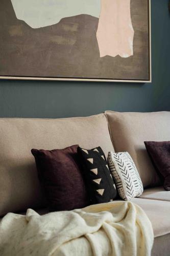 a couch with pillows and a blanket on it at Clemonte Hotel - Your Reception-less Boutique Hideaway in Salzburg